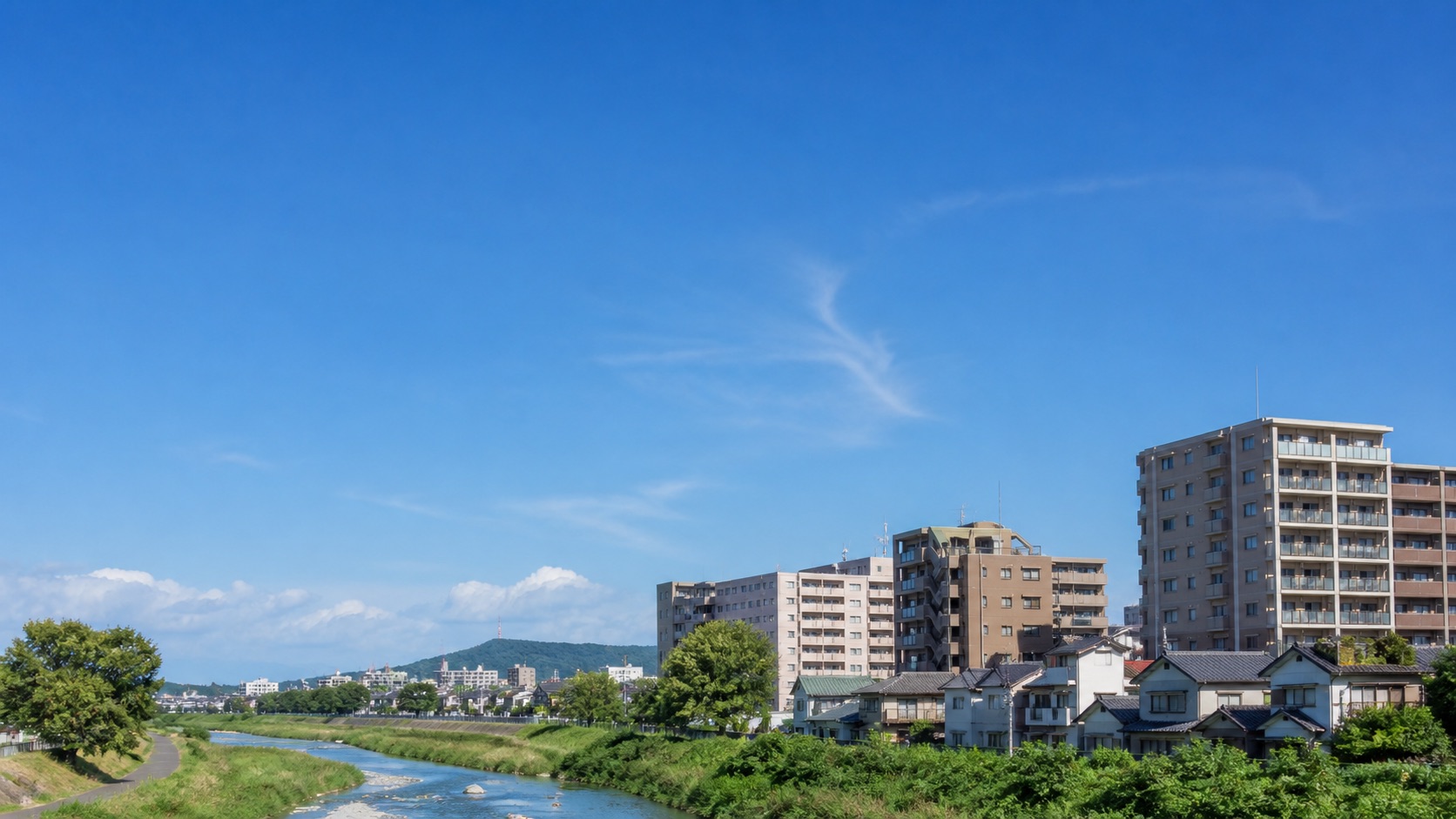 青空の下に広がる伊丹周辺の街並みと川辺